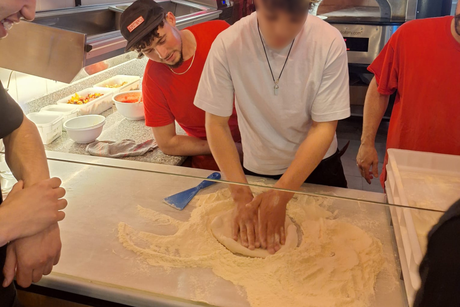 Un joven prepara la masa de la pizza